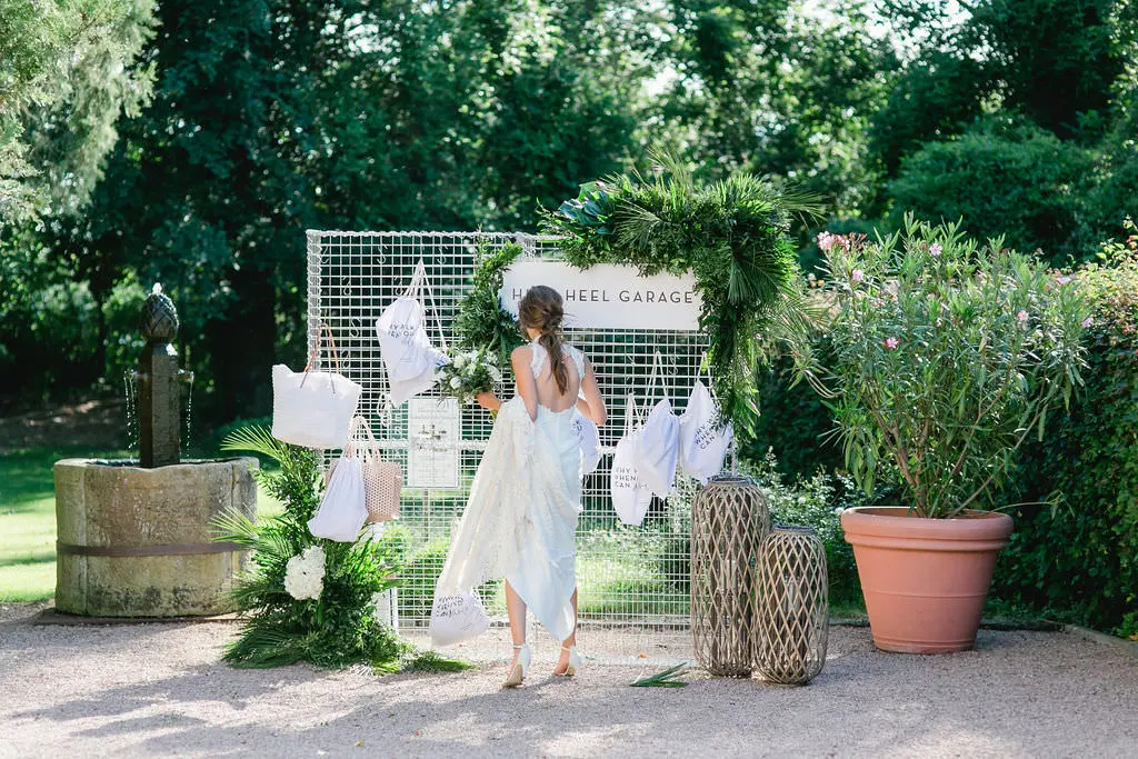 Braut an der High Heel Garage im Garten