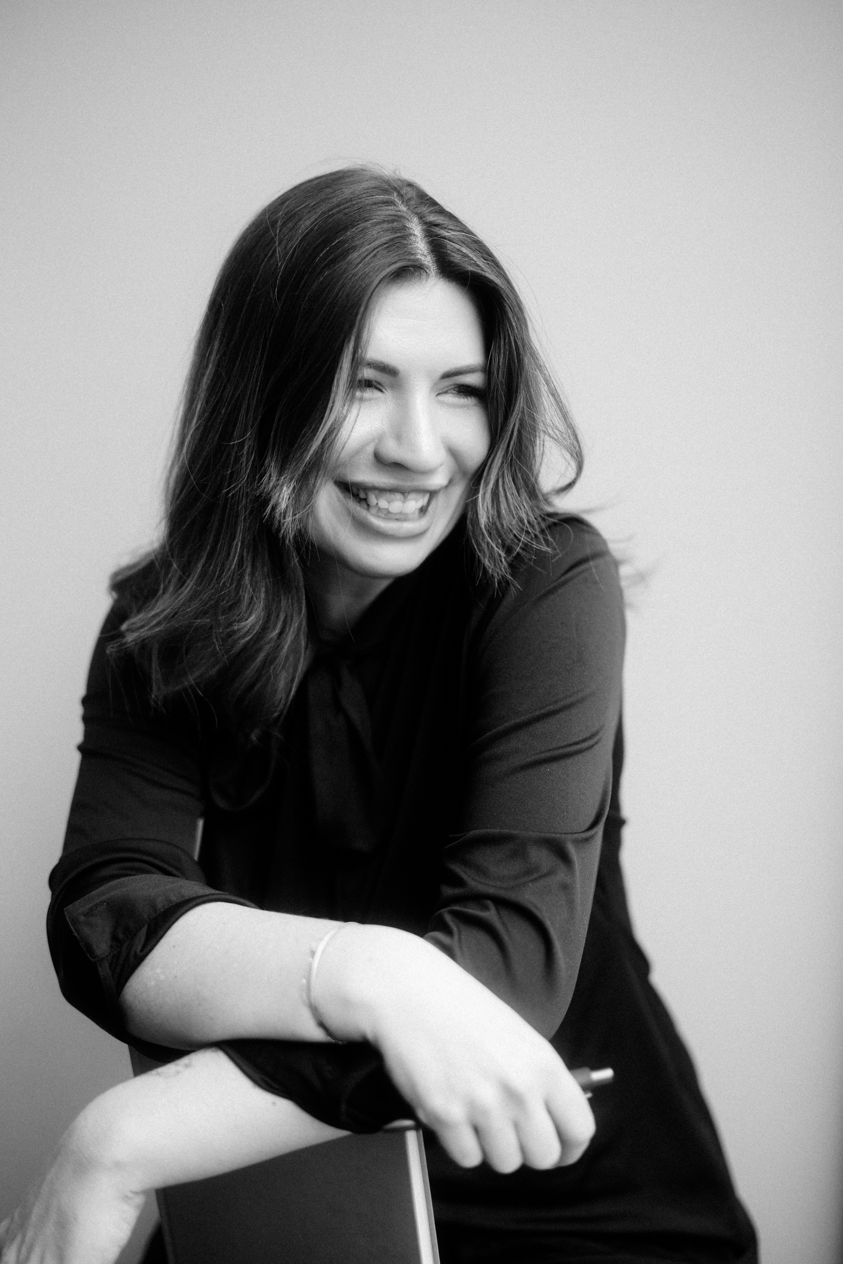Annika lacht, mit Stift und Notizbuch